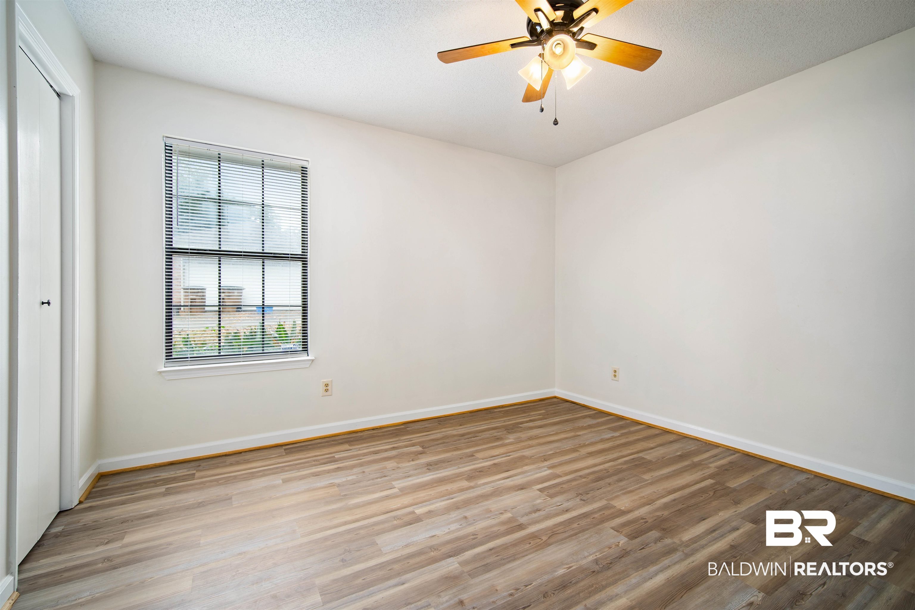 6701 Howells Ferry Road Mobile, AL 36618 - Photo 20 of 25 Unfurnished room featuring ceiling fan, a textured ceiling, and light wood-type flooring