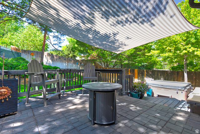 3310 Creek Road Salt Lake City, UT 84121 - Photo 38 of 49 Outdoor living area featuring a striped shade sail over a stone paver patio
