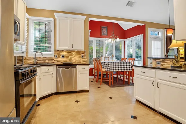 a kitchen with stainless steel appliances a stove a sink and a microwave