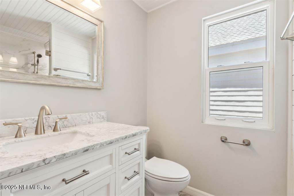 22 Belted Kingfisher Road Fernandina Beach, FL 32034 - Photo 37 of 70 a bathroom with a granite countertop sink toilet a mirror and shower