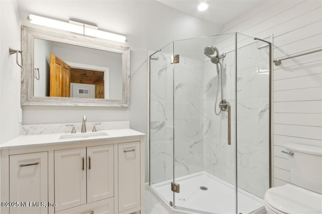 22 Belted Kingfisher Road Fernandina Beach, FL 32034 - Photo 41 of 70 a bathroom with a shower sink vanity and mirror