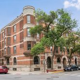 a couple of cars parked in front of brick building