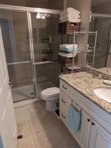 a bathroom with a granite countertop sink a toilet and shower