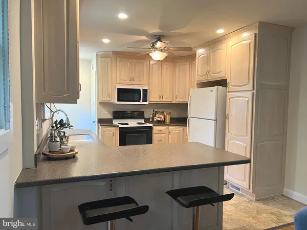 a kitchen with refrigerator and cabinets