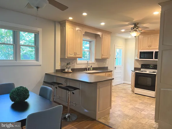 a kitchen with kitchen island a sink stainless steel appliances and a dining table