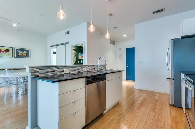 a kitchen with stainless steel appliances granite countertop a sink stove and refrigerator