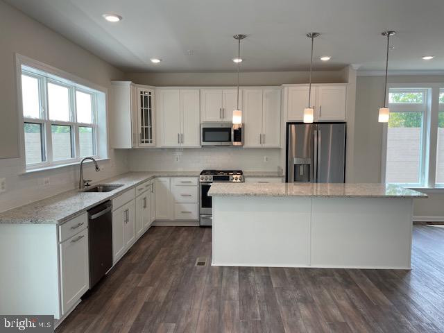 8235 Front Loop Rockville, MD 20855 - Photo 5 of 22 a large kitchen with stainless steel appliances kitchen island a large counter top a sink cabinets and a window