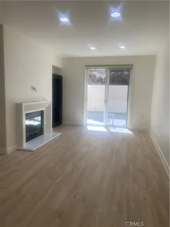 an empty room with windows and fireplace
