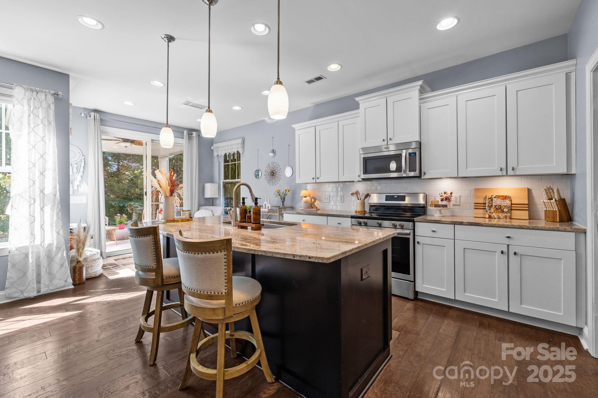 324 Windell Drive Fort Mill, SC 29708 - Photo 8 of 47 a kitchen with stainless steel appliances granite countertop a stove a sink a microwave a center island and a cabinets