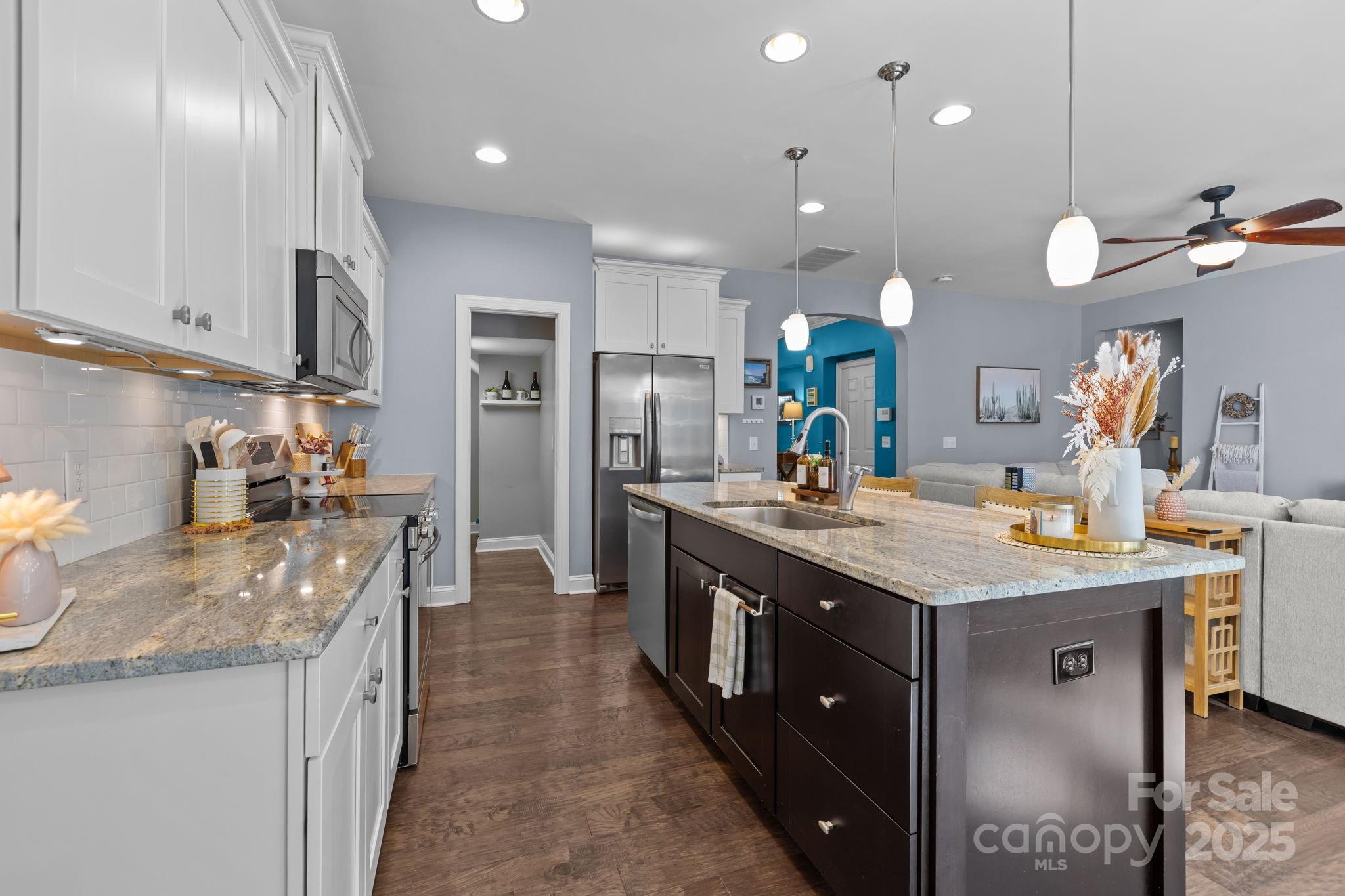 324 Windell Drive Fort Mill, SC 29708 - Photo 10 of 47 a large kitchen with granite countertop a large island in the center a sink stainless steel appliances and cabinets
