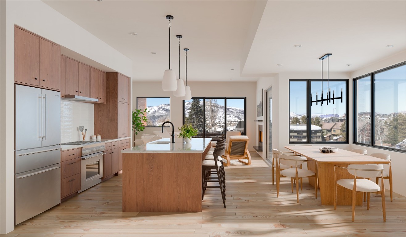 2075 Walton Creek Road, Unit 2B Steamboat Springs, CO 80487 - Photo 2 of 8 a view of a dining room with furniture large windows and wooden floor