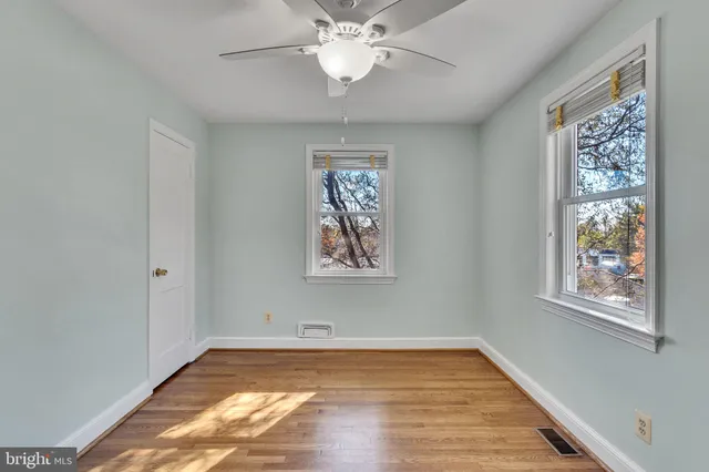 a view of empty room with window and ceiling fan