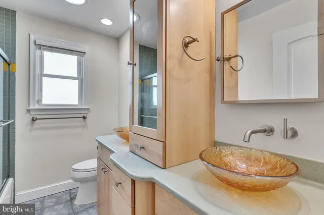 a bathroom with a toilet a sink and a mirror