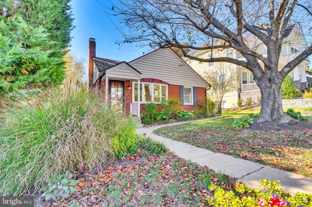 a yellow house with flower garden in front of it