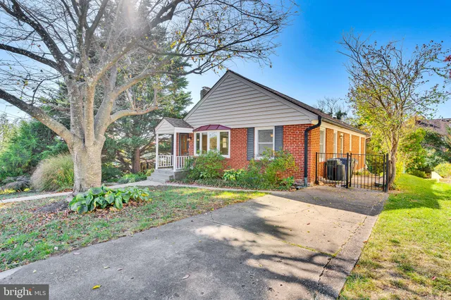 a front view of a house with a yard and trees