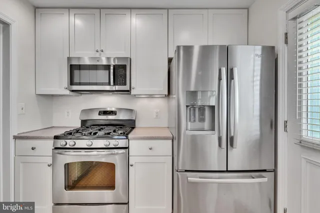 a kitchen with stainless steel appliances a refrigerator stove and microwave