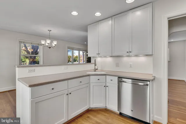 a kitchen with white cabinets and sink