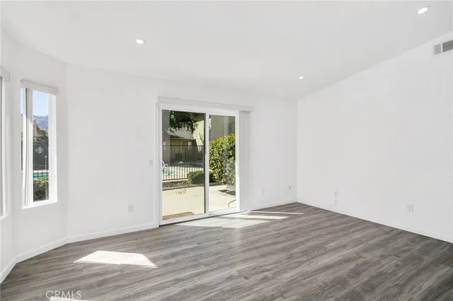 a view of an empty room with wooden floor