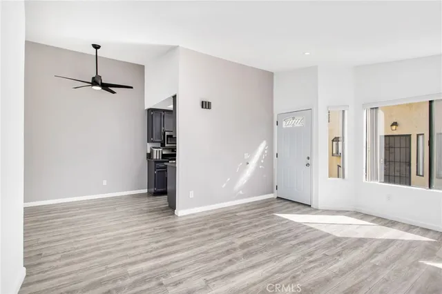 a view of room with a ceiling fan and wooden floor