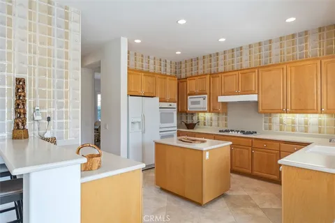 a kitchen with stainless steel appliances granite countertop a sink a stove and a refrigerator