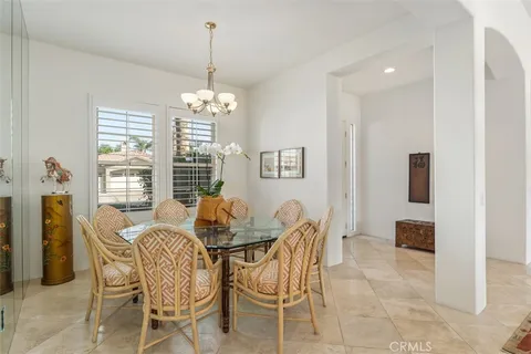 a dining room with furniture a chandelier and window