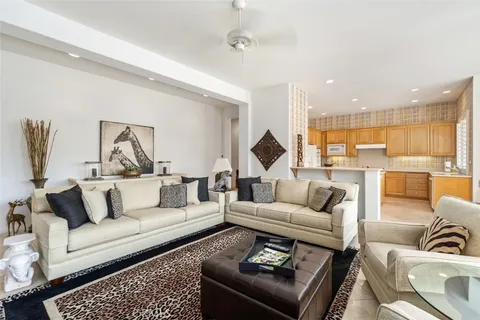 a living room with furniture and a view of kitchen