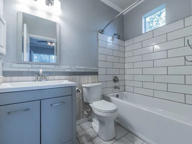 a bathroom with a sink mirror toilet and bathtub