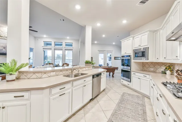 a kitchen with appliances cabinets and chair