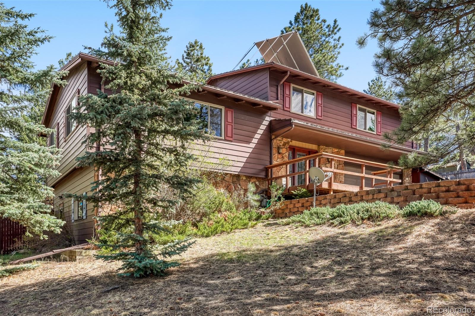 3518 South Saddle Road Evergreen, CO 80439 - Photo 1 of 27 a front view of a house with a yard
