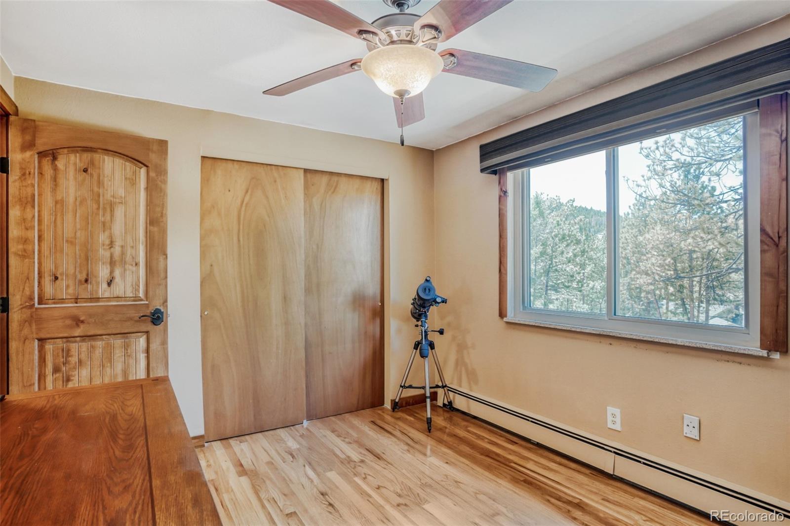 3518 South Saddle Road Evergreen, CO 80439 - Photo 13 of 27 a view of an empty room with a window and wooden floor