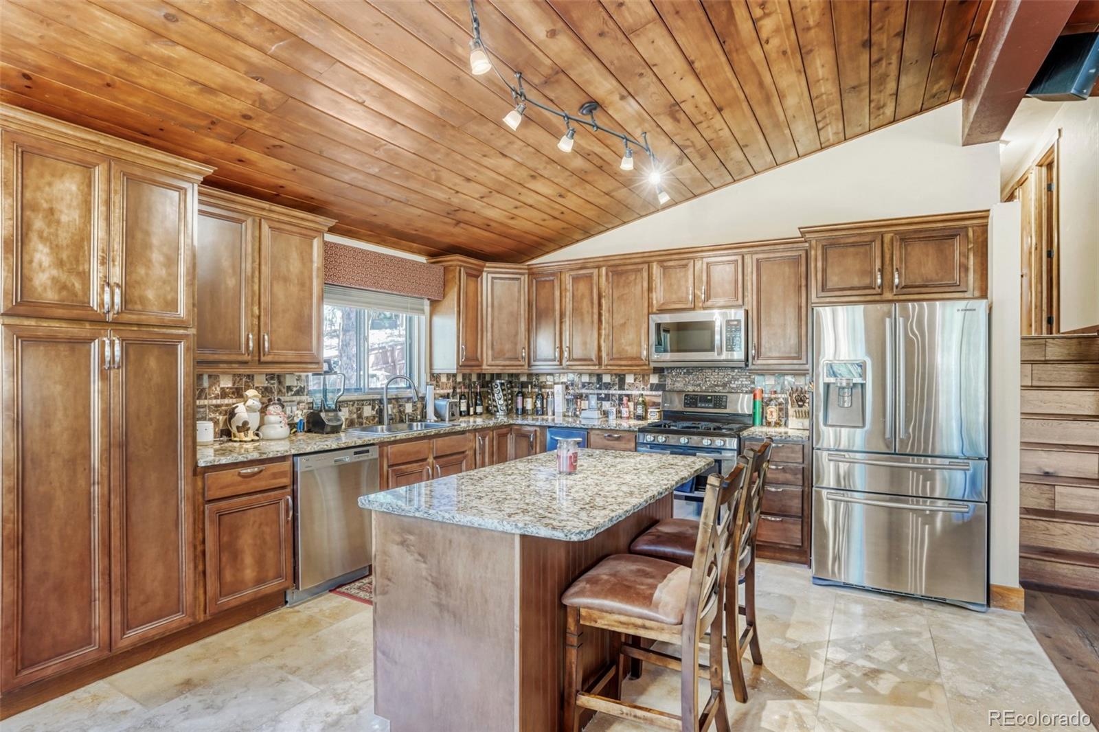3518 South Saddle Road Evergreen, CO 80439 - Photo 6 of 27 a kitchen with granite countertop a refrigerator stove top oven and sink