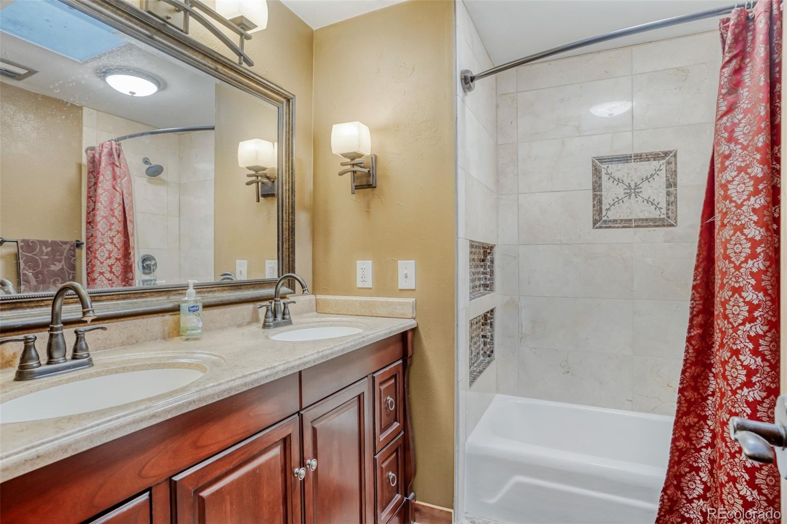 3518 South Saddle Road Evergreen, CO 80439 - Photo 10 of 27 a bathroom with a granite countertop sink and a mirror a bathtub