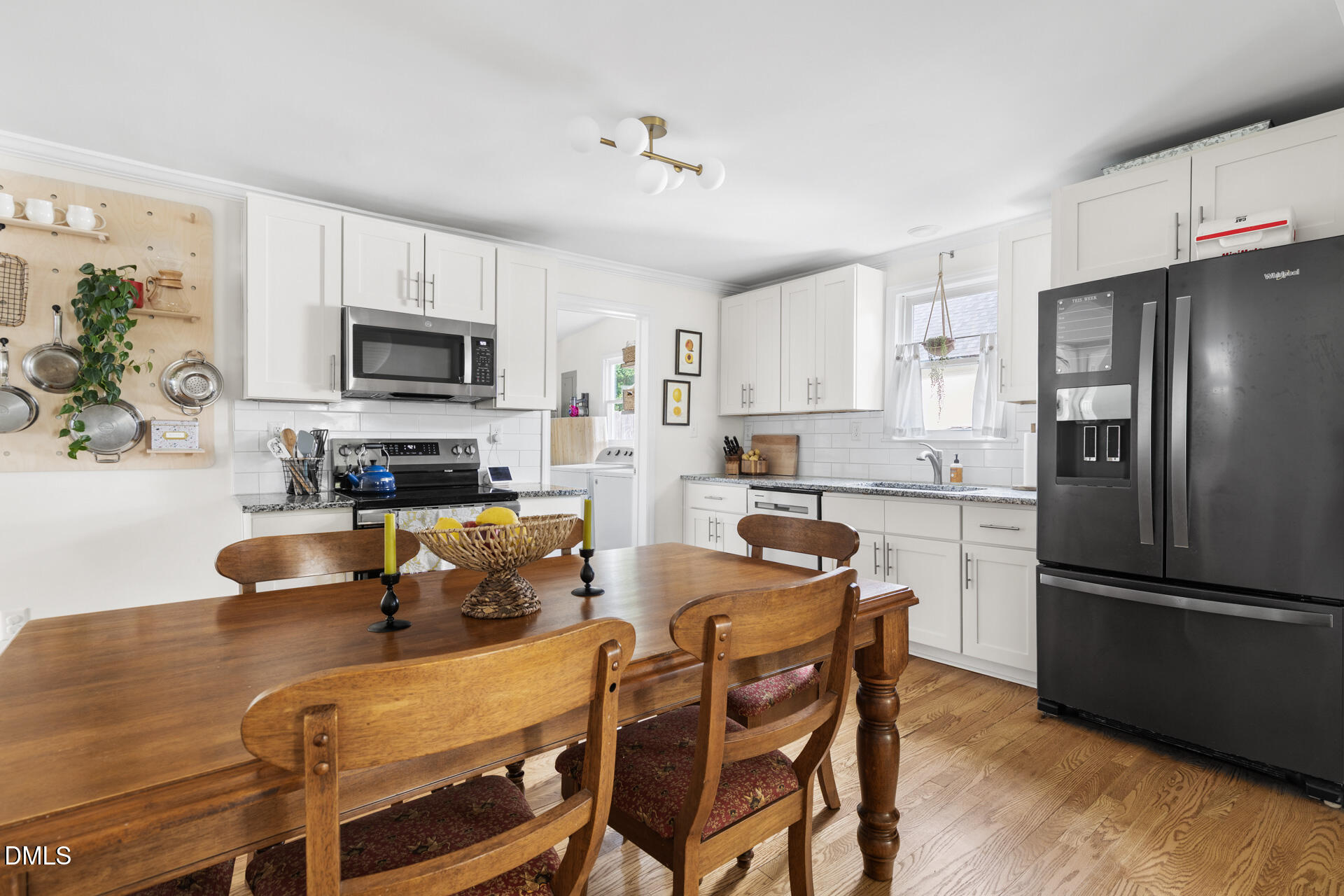 608 Canal Street Durham, NC 27701 - Photo 18 of 36 a kitchen with stainless steel appliances granite countertop a refrigerator a stove a sink a microwave a dining table and chairs with wooden floor