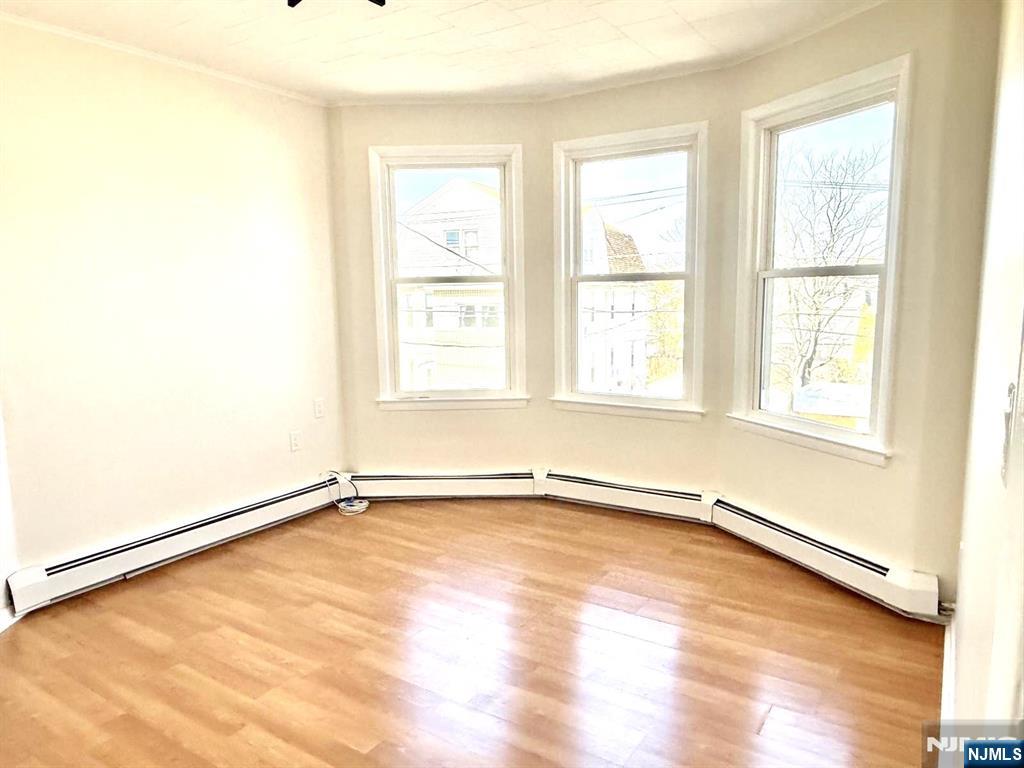 210-212 Maple Street, Unit 2 Kearny, NJ 07032 - Photo 2 of 9 an empty room with wooden floor and windows