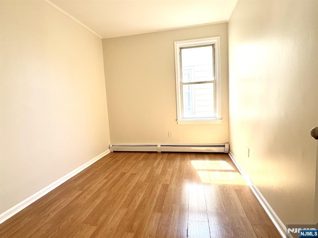 210-212 Maple Street, Unit 2 Kearny, NJ 07032 - Photo 6 of 9 an empty room with wooden floor and windows