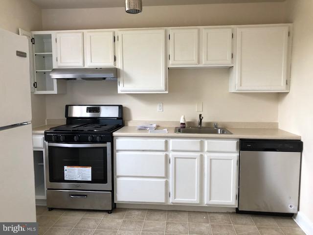 6427 Walther Avenue, Unit E Baltimore, MD 21206 - Photo 5 of 17 a kitchen with granite countertop white cabinets and stainless steel appliances