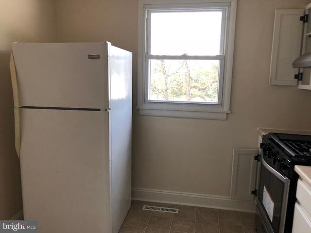 6427 Walther Avenue, Unit E Baltimore, MD 21206 - Photo 6 of 17 a white refrigerator freezer and a stove sitting inside of a kitchen