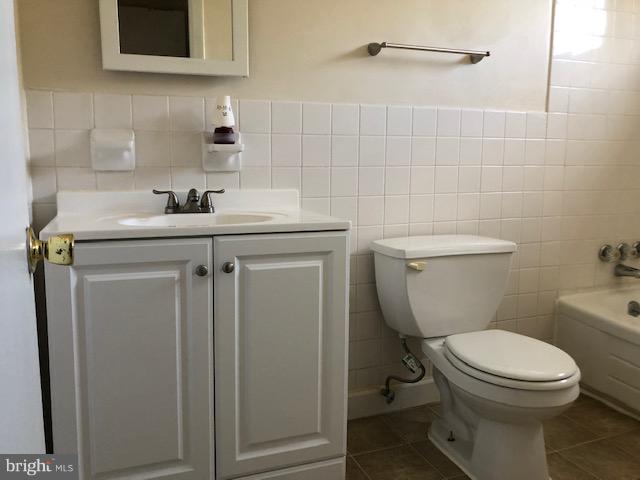 6427 Walther Avenue, Unit E Baltimore, MD 21206 - Photo 9 of 17 a bathroom with a toilet a sink and mirror