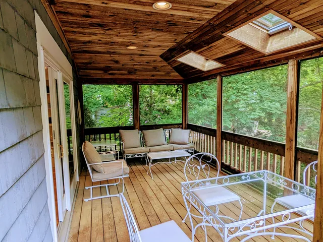 a view of a patio with a table chairs and a wooden floor