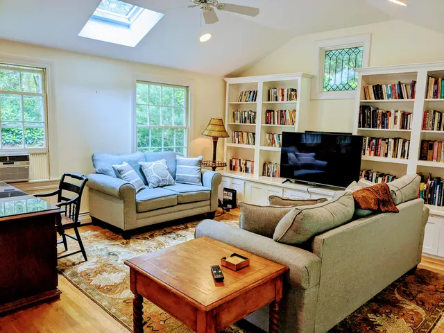 a living room with furniture and a book shelf