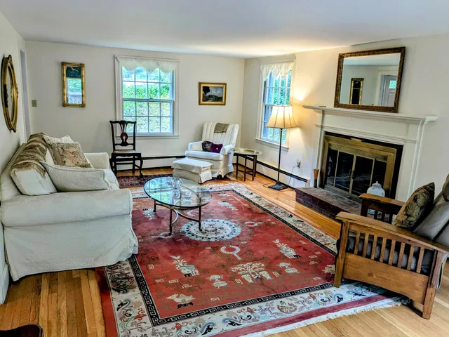 a living room with furniture a rug and a fireplace