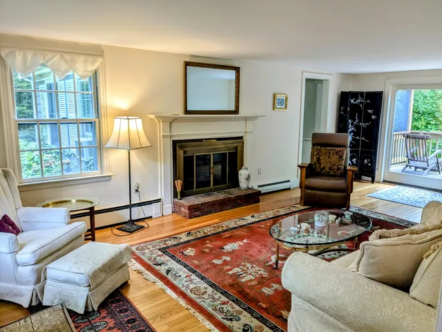 a living room with furniture fireplace and a large window