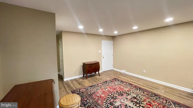 a living room with a rug and a wooden floor