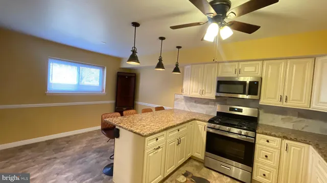 a kitchen with stainless steel appliances granite countertop a stove and a microwave
