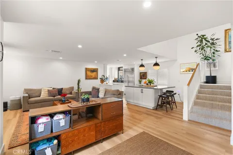 a living room with furniture and a dining table with kitchen view