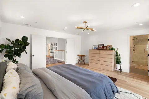 a bedroom with a bed chandelier and a window