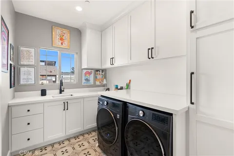 a utility room with cabinets washer and dryer