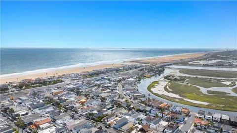 an aerial view of ocean beach and residential houses with outdoor space