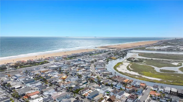 an aerial view of ocean beach and residential houses with outdoor space