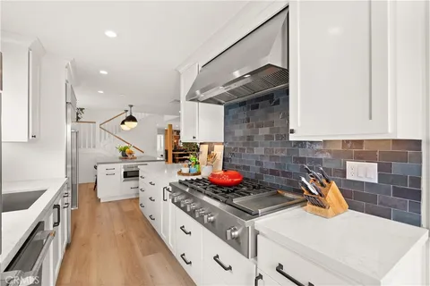 a kitchen with a stove and white cabinets